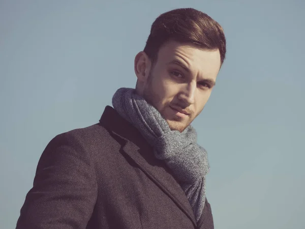 Uomo o modella in cappotto, sciarpa su cielo blu — Foto Stock