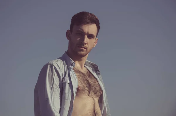 Sexy man poseren in ontknopen shirt met harige, naakte borst — Stockfoto