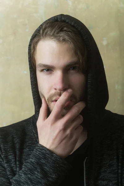 Joven escondido sin afeitar la cara con la mano con capucha gris —  Fotos de Stock