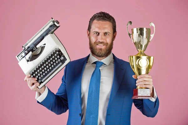 Щасливий бізнесмен з друкарською машинкою і золотим кубком чемпіонів — стокове фото