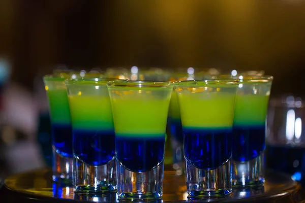 Blau und gelb geschichtete Schützen oder Cocktails in Schnapsgläsern, — Stockfoto