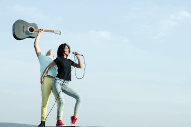 Seksi şarkıcı şarkı gitar ile mikrofon yakışıklı gitarist