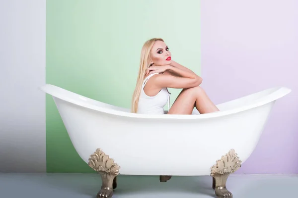 Leidenschaftliches blondes Mädchen mit knallrotem Lippenstift im weißen Badezimmer — Stockfoto