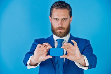 mavi arka plan üzerinde kredi kartı tutan adam