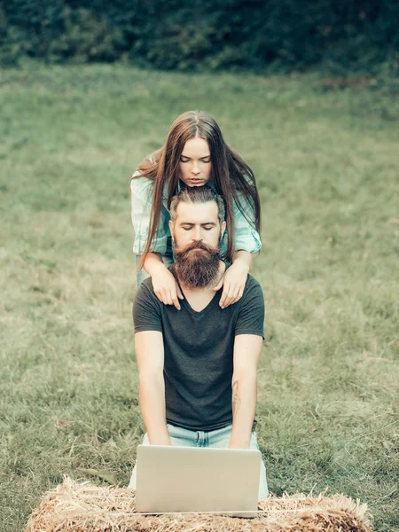 Mädchen und bärtiger Mann mit Laptop in der Natur — Stockfoto