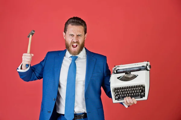 Hombre de negocios, hombre de negocios agresivo con máquina de escribir y martillo — Foto de Stock