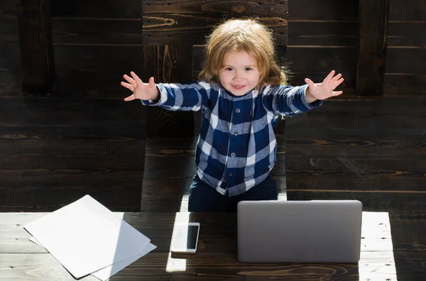 Niño feliz en la oficina con el ordenador portátil, teléfono, hoja de papel — Foto de Stock