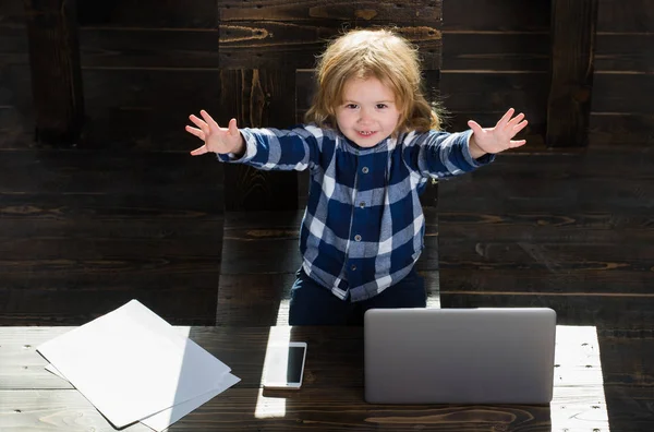 Menino feliz no escritório com laptop, telefone, folha de papel — Fotografia de Stock