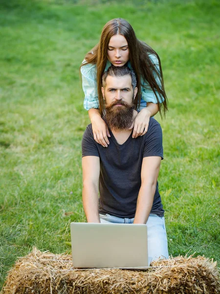 Ember és aranyos lány használ laptop, a természet — Stock Fotó