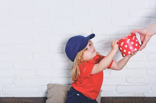 Lächelndes glückliches Kind in blauer Mütze mit Geschenkbox — Stockfoto
