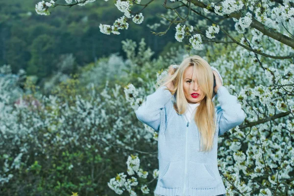 Meisje met de rode lippen en blonde haren in bloei — Stockfoto