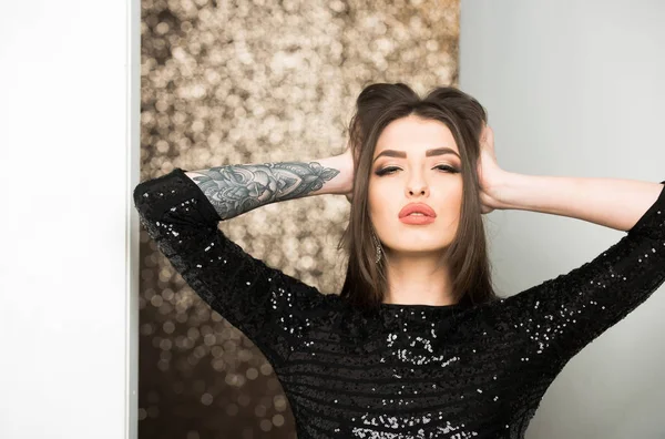 Mooie mode vrouw in zwarte pailletten jurk poseren met Tattoo — Stockfoto