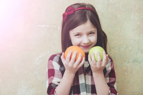 Ovoce v blízkosti šťastný obličej, Holčička s zelené jablko, pomeranč — Stock fotografie