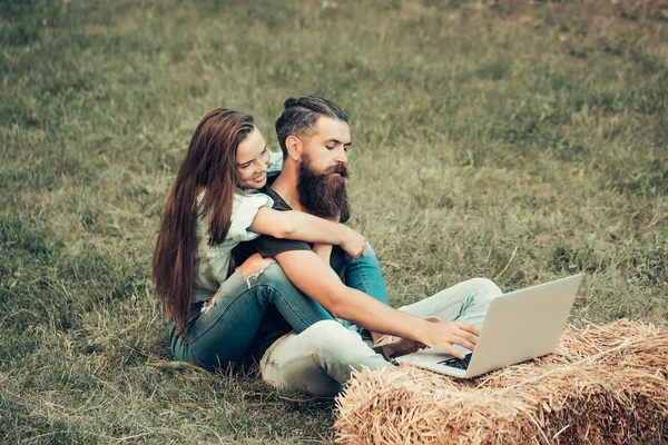 Feliz chica abrazo barbudo hombre hipster trabajando en portátil —  Fotos de Stock