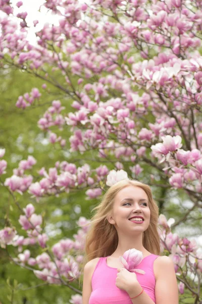 Meisje in mooie bloemen roze kleur Magnoliaboom — Stockfoto