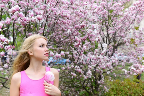 Mooi meisje houdt magnolia bloem bloeiende boom, lentetuin — Stockfoto