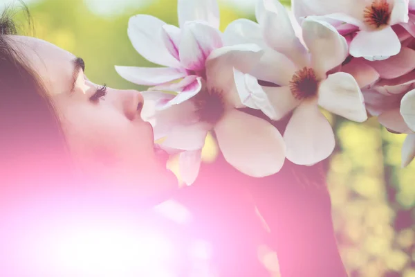 ツリーからピンク、開花、マグノリアの花の臭いがする女の子 — ストック写真