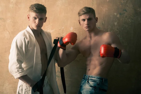 Homens atléticos gêmeos em karatê kimono e luvas de boxe — Fotografia de Stock