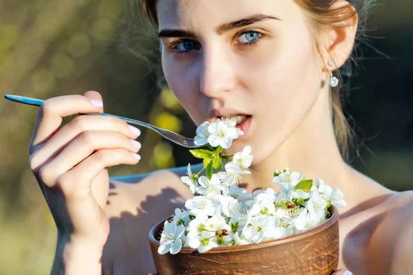 Schöne Frau oder niedliches Mädchen, das Blumen isst, Frühlingskirschblüte — Stockfoto