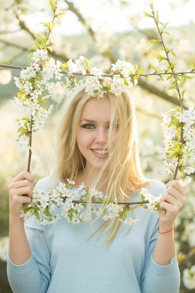 Fille heureuse souriant dans le cadre de blanc, fleurs florissantes — Photo