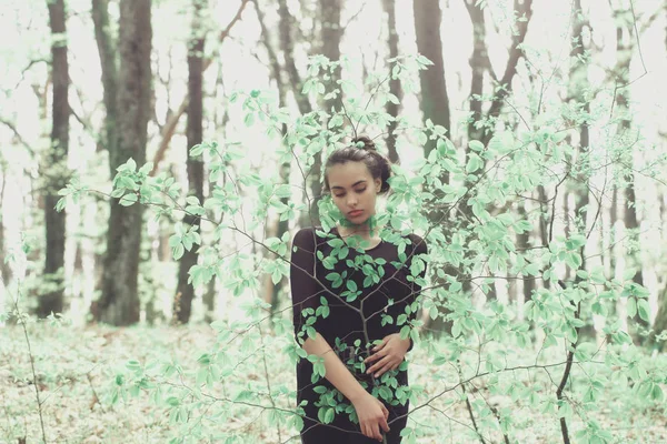 Fille se cachant dans les feuilles d'arbre vert dans la forêt de printemps — Photo