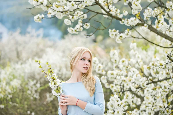 Красота и природа, девушка, держащая в руках ветви белых, распускающихся цветов — стоковое фото