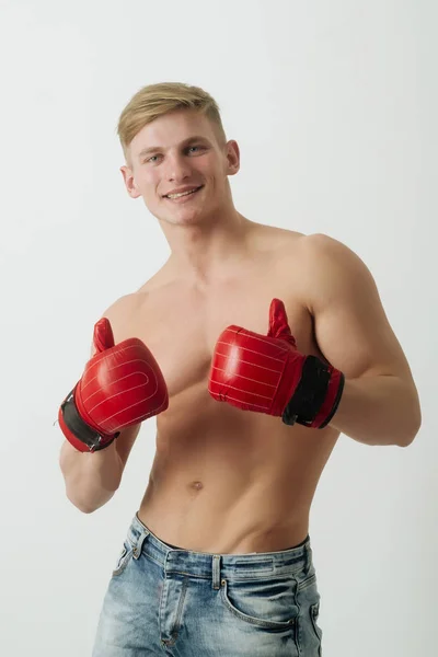 Щасливий чоловік, боксер показує великі пальці з червоними, боксерські рукавички — стокове фото