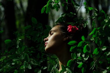 güzel kırmızı çiçek saç yeşil yaprakları içinde kadın