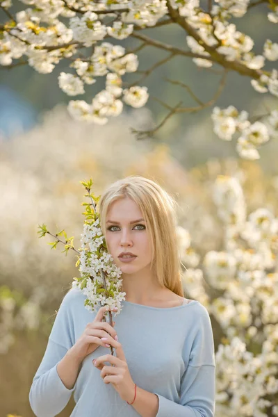Mooie jonge vrouw in de bloeiende lentetuin — Stockfoto