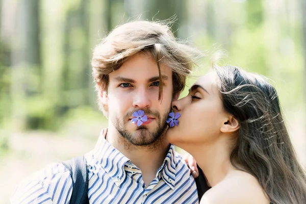 Женщина целует мужчину на естественном фоне — стоковое фото