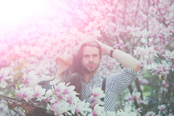 Чоловік і красива дівчина насолоджується цвітінням квітки магнолії — стокове фото