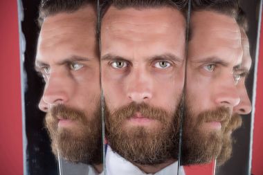 face of serious bearded hipster man, businessman reflecting in mirror clipart
