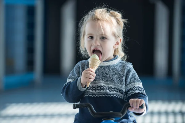Bambino in maglione che mangia, leccare il gelato — Foto Stock