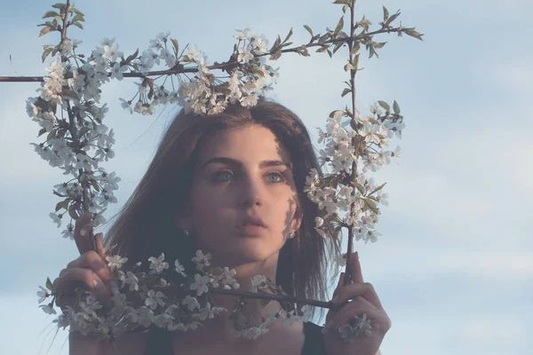 Sevimli kız mavi gökyüzü üzerinde çerçeve çiçek poz