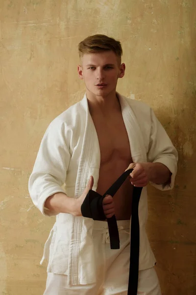 Arte marcial y energía, hombre de karate envolviendo cinturón negro — Foto de Stock