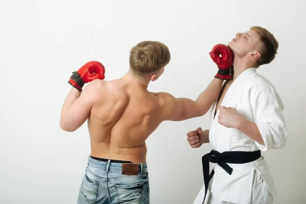 Boxeador golpeando joven atleta de karate — Foto de Stock