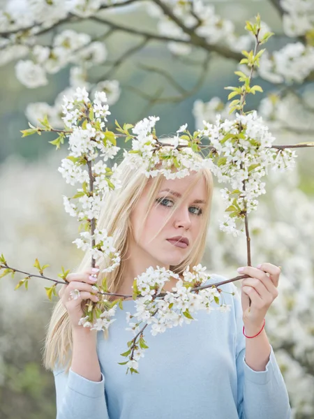 Mooie jonge vrouw genieten van geur in een bloeiende lentetuin — Stockfoto