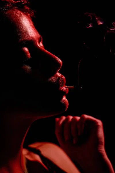 目を閉じて口の中で喫煙の一致を保持している女性 — ストック写真