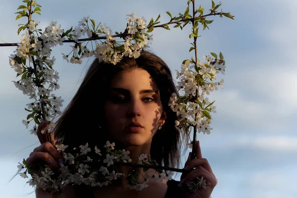 Bela jovem mulher em uma moldura de primavera florida no céu — Fotografia de Stock