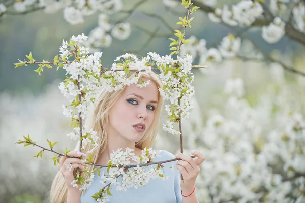 Adorable mujer sosteniendo marco de flores blancas en flor — Foto de Stock