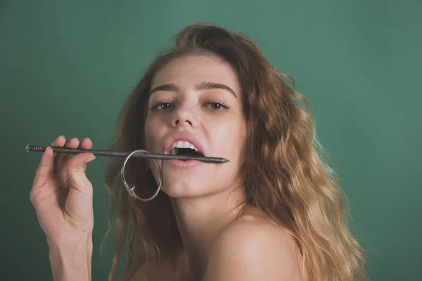 Жінка з металевим цвяхом у роті, що показує здорові зуби — стокове фото