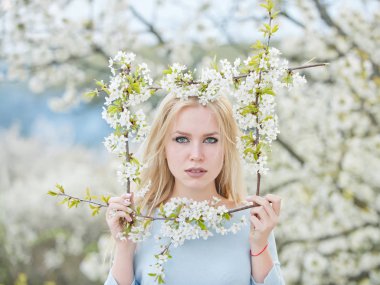 Bahar çiçek çerçeve kiraz bahçesinde bulunan güzel genç kız