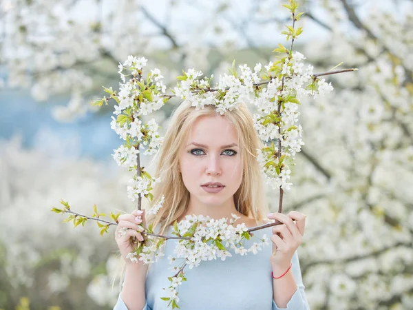 Frühlingsblumenrahmen im Kirschgarten mit schönem jungen Mädchen — Stockfoto