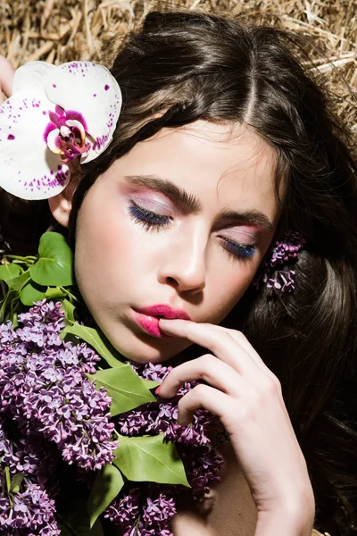 Portrét mladé ženy, dívka s krásnou lila, květ orchideje — Stock fotografie