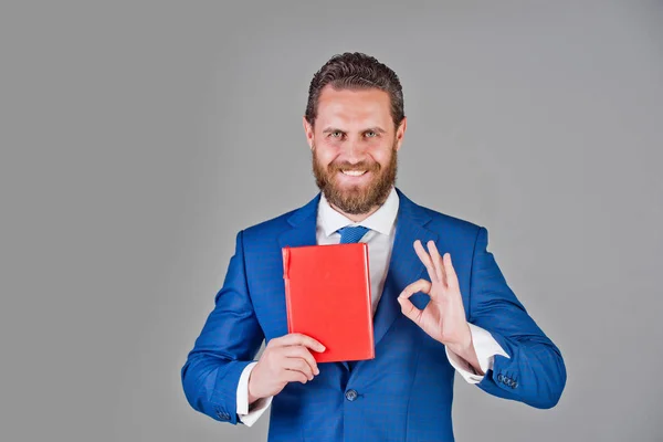 Homem, homem de negócios feliz segurar notebook, livro vermelho na mão — Fotografia de Stock