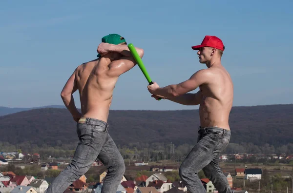 Сильные спортсмены с атлетическими туловищами, сражающиеся бейсбольной битой — стоковое фото