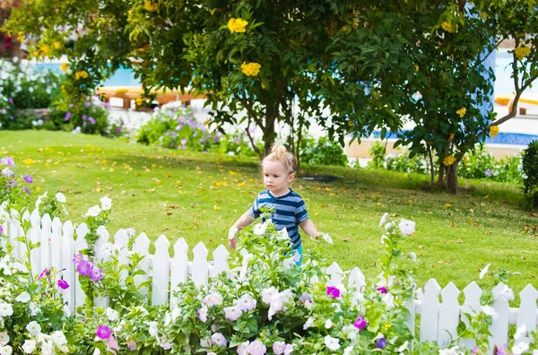 Bambino piccolo bambino all'aperto vicino a recinzione in legno bianco — Foto Stock
