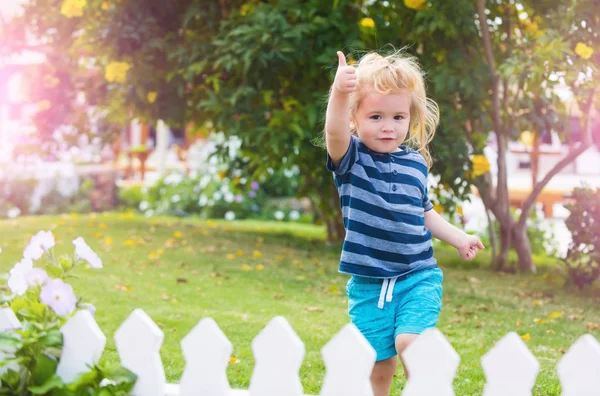 Kid eller liten pojke utomhus nära vitt trästaket — Stockfoto