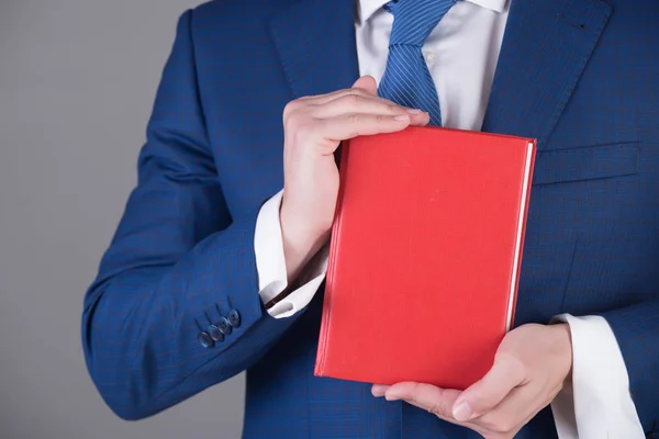 Rotes Lesebuch in der Hand eines jungen Mannes oder Geschäftsmannes — Stockfoto