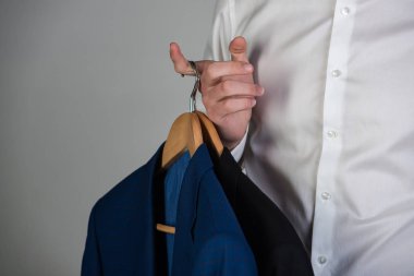 Askı tişörtlü adam elinde resmi ceket ile